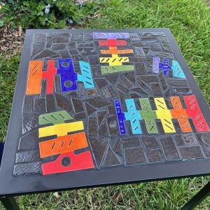 Trish Nugent outdoor table. Mosaic with artist-made tiles on a patio side table base. Rainbow colors
