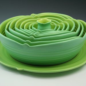 Marge Margulies 8 ceramic bowls in lime green nested onto a serving plate. Inspired by the gorgeous geometry of succulent plants, these ceramic functional centerpieces grace the table and add color to the room.